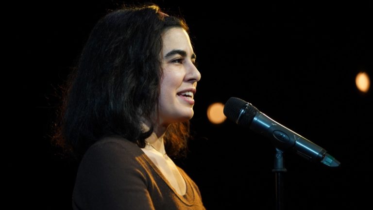 Roxanne Khamsi speaking into a microphone